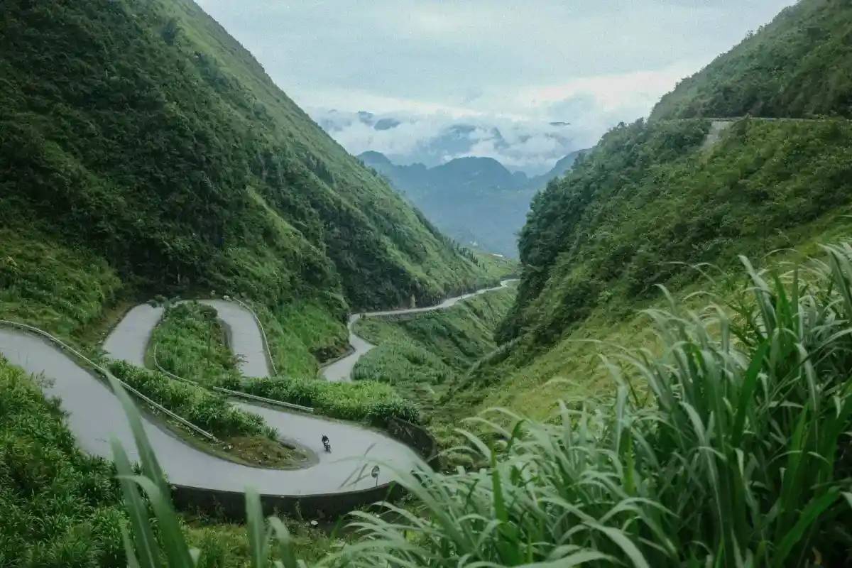 A road winding through a green valley in Yen Minh